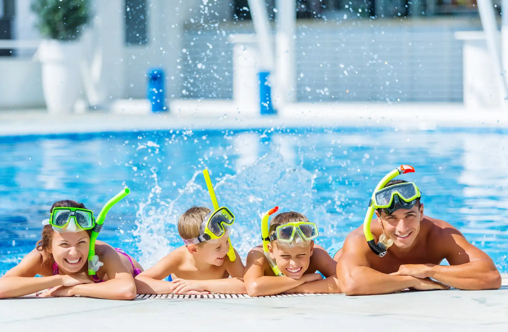 Happy family with snorkeling gear in swimming pool - Family vacation fun